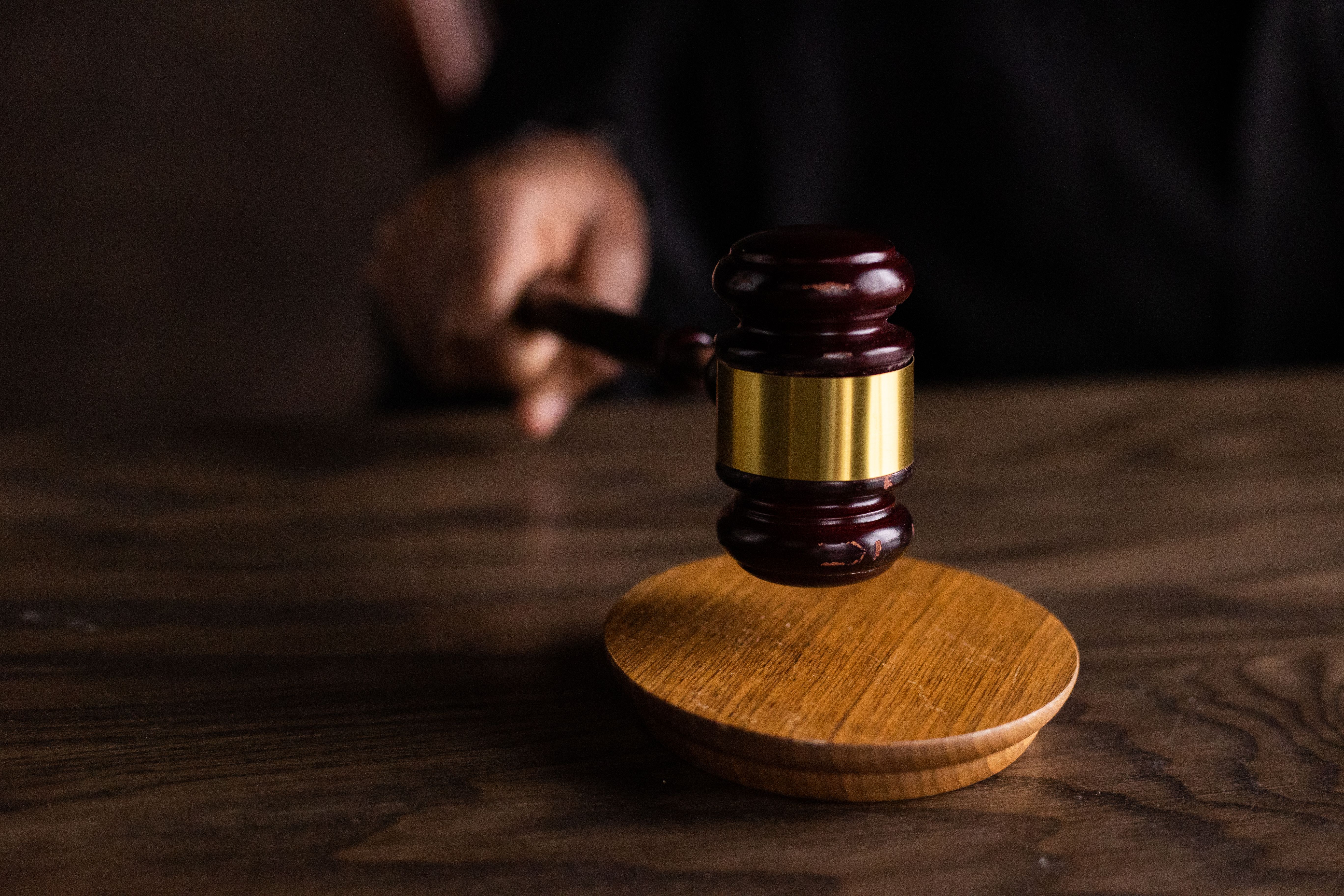 A gavel striking a sound block in a courtroom, symbolizing legal authority and high-stakes litigation